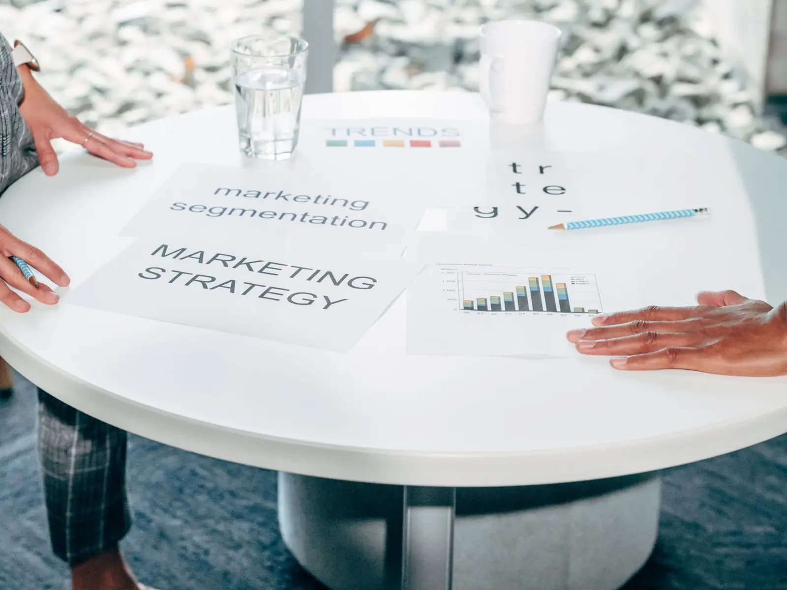 Two people reviewing marketing strategy documents at a round table
